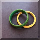 J142. 2 Bakelite bangles in different widths. One yellow and one green.